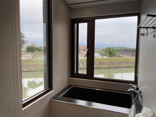 a bathroom with a sink and two windows at Muco Muco Bnb in Yilan City