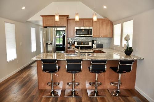 a kitchen with a large island with bar stools at Luxurious Historic Renovated Bungalow DT Rapid City with Private Patio in Rapid City