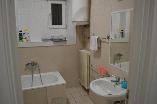 a bathroom with a sink and a toilet and a tub at Lazarus Apartment in Skopje