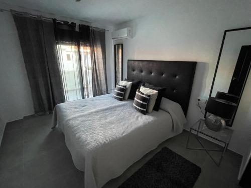 1 dormitorio con cama con almohadas y ventana en Enjoy Spain - La Maestranza, en Marbella
