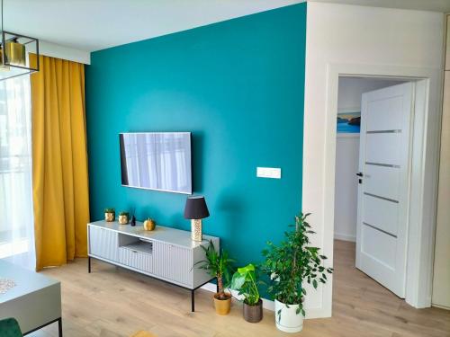 Apartament nr15 z parkingiem podziemnym في تورون: غرفة معيشة بحائط ازرق