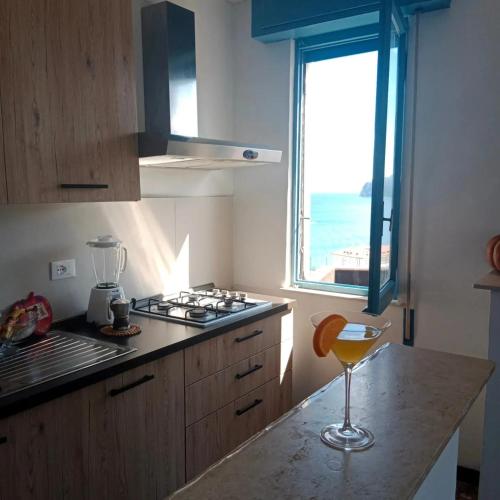 a kitchen with a counter with a stove and a window at Casa del sole in Spotorno