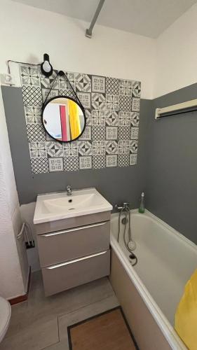 une salle de bain avec un lavabo, une baignoire et un miroir dans l'établissement Lumineux studio vue mer, à Sainte-Maxime