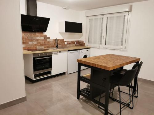- une cuisine avec une table en bois et un comptoir dans l'établissement Appart43m² Proche Gare et Centre, à Cholet