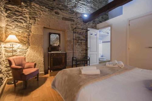 ein Schlafzimmer mit einem Bett, einem Stuhl und einem Fenster in der Unterkunft Casa Taboada in Sarria