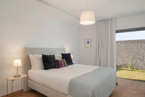1 dormitorio con cama blanca y ventana en CASA DO MIRADOURO 7 by Heart of Funchal, en Funchal