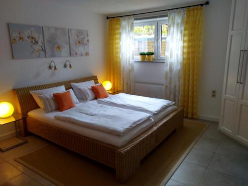クロルト・ゴーリッシュにあるFerienwohnung am Wäldchenのベッドルーム1室(オレンジ色の枕と窓付)
