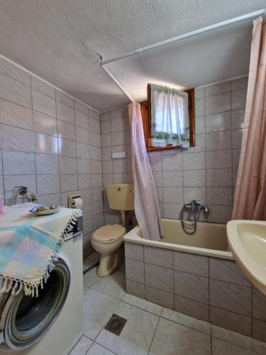 a bathroom with a toilet a sink and a washing machine at Dream in Chalkidiki 2 bedroom villa with garden in Néa Tríglia