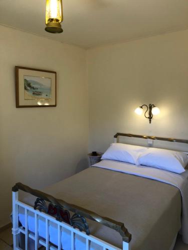 ein Schlafzimmer mit einem Bett mit weißen Kissen in der Unterkunft ARETI Sea View Mountain Cottage in AmigdhalokeFálion