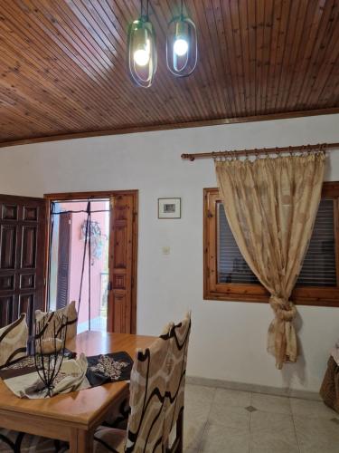 a dining room with a table and a window at Dream in Chalkidiki 2 bedroom villa with garden in Néa Tríglia