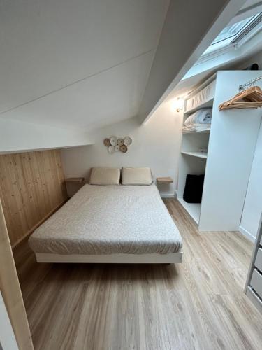 um pequeno quarto com uma cama e um sótão em Magnifique Maison forêt & Mer avec piscine - Wifi em Saint-Jean-de-Monts