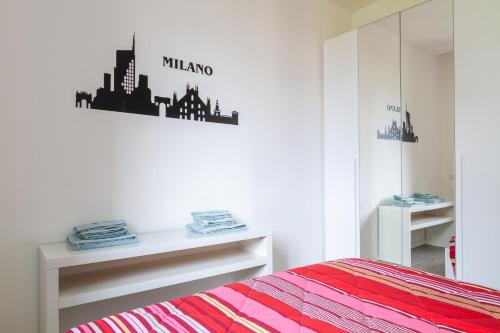 1 dormitorio con 1 cama y un cartel de la ciudad en la pared en LUX Apartment Milano Metro M2, en Milán