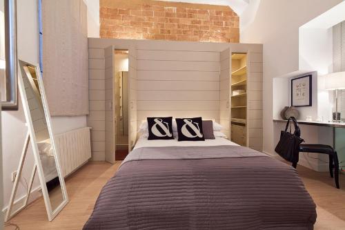 a bedroom with a large bed and a brick wall at Cathedral Apartment in Barcelona