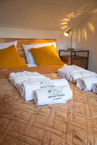 three stacks of towels sitting on top of a bed at Ironland Roztocze in Ruda Żelazna