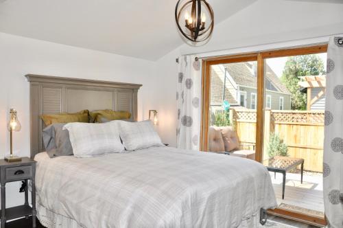 a white bedroom with a bed and a large window at Adorable Bungalow w/ Private Patio Mins away from Downtown Rapid City in Rapid City