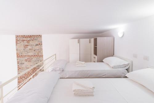 Duas camas num quarto com paredes brancas em Loft via morosini centro Varese - IXIHOME em Varese