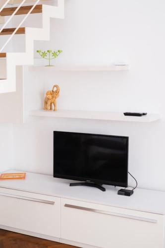 a flat screen tv sitting on top of a white entertainment center at Loft via morosini centro Varese - IXIHOME in Varese