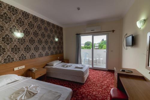 a hotel room with two beds and a window at Grand Hotel Derin-All Inclusive in Beldibi