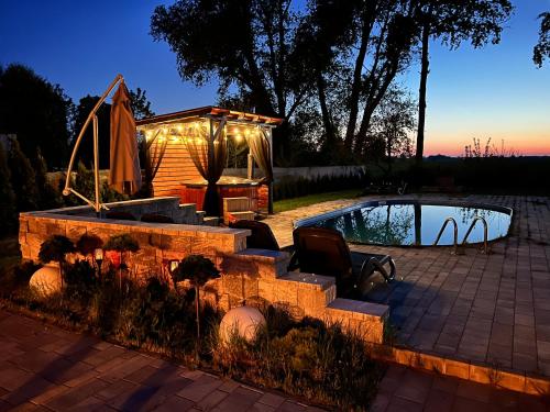 a backyard with a pool and a gazebo at Black Horse in Pasłęk