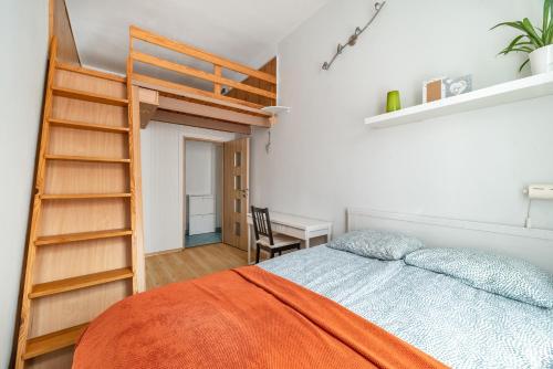 a bedroom with a bed with a ladder and a desk at Rooms in City Center in Gdańsk