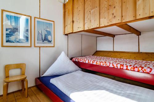 a bedroom with two bunk beds and a chair at Adlerhorst über dem Bodensee in Sipplingen
