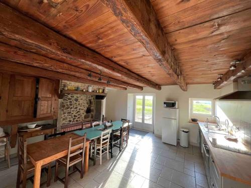 een keuken met houten plafonds en een tafel en stoelen bij Grand Gîte Confortable en Auvergne - Belle vue in Brousse