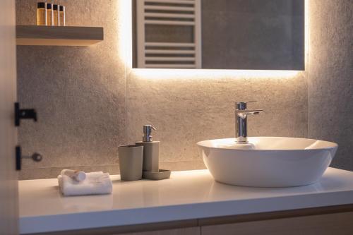 a bathroom with a white sink and a mirror at Aeson Premium Living in Volos
