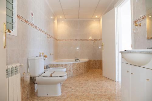 uma casa de banho com um WC, uma banheira e um lavatório. em VILLA ADELAIDA em L'Eucaliptus