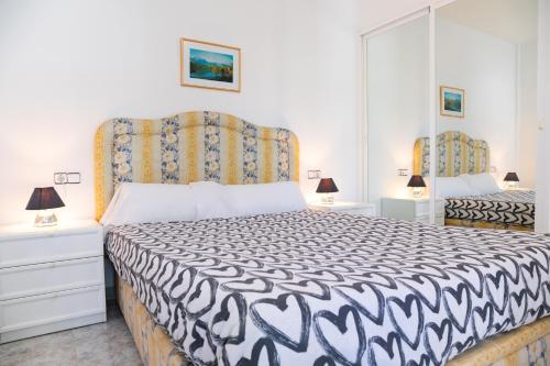 um quarto com uma cama com um edredão preto e branco em VILLA ADELAIDA em L'Eucaliptus