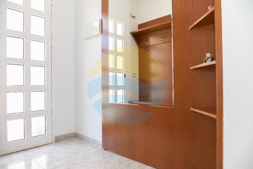 a kitchen with a wooden cabinet and a door at VILLA ADELAIDA in L'Eucaliptus