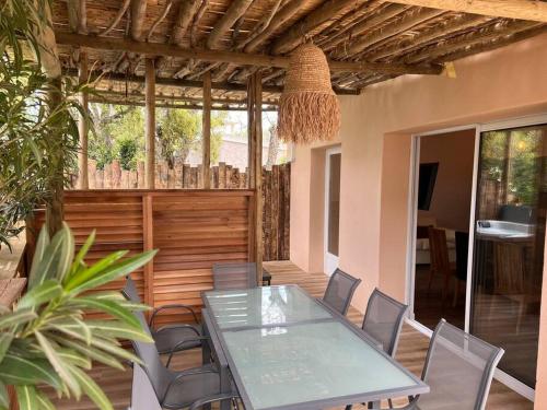 une salle à manger avec une table et des chaises en verre dans l'établissement T3 avec spa, hyper centre, port, à Porto-Vecchio