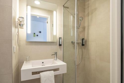 a bathroom with a sink and a shower at B&B HOTEL Mechelen in Mechelen