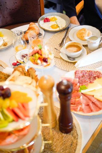 una mesa cubierta con platos de comida. en Albergo Diffuso ELA Living - Design Apartment & Room, en Egna