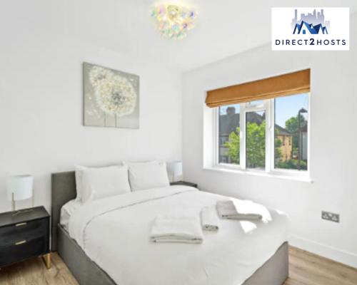 una camera bianca con un letto e una finestra di Three Bedroom Beautiful & Comfy Acton Gem Apartment by Direct2hosts With King Beds & Free Parking! a Londra