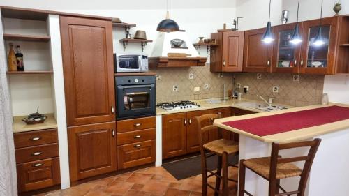 a kitchen with wooden cabinets and a stove top oven at Villa Sinforosa - Mondello in Mondello