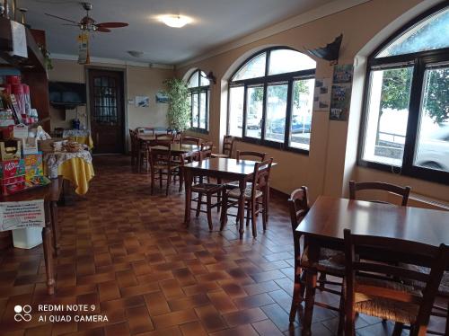 a dining room with tables and chairs and windows at Il Vapore in Oggebbio