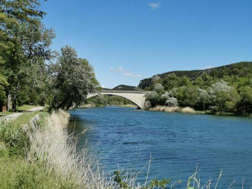 een brug over een rivier met blauw water bij Studio in Gréoux-les-Bains