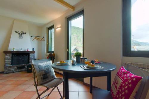 ein Wohnzimmer mit Tisch und Kamin in der Unterkunft Casa Camino - 200m dagli impianti del Baradello in Corteno Golgi