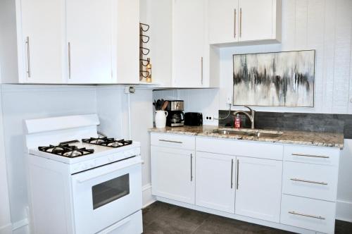 uma cozinha branca com um fogão e um lavatório em Downtown 1 Bedroom Charmer - Walk, Bike, Enjoy!! em Rapid City