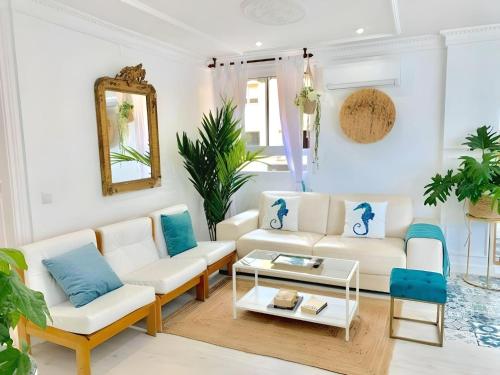 sala de estar con muebles blancos y detalles en azul en Lux City Loft in front of the Port, en Alicante