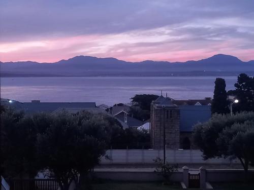 a view of the water and a city with a sunset at Barmarine Luxury Holiday Home in Mossel Bay