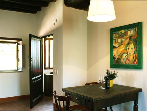 a dining room with a table and a painting on the wall at Torrione Apartment in Panzano
