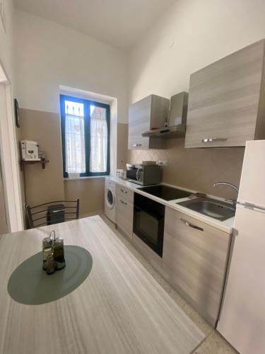 uma cozinha com uma mesa e um frigorífico em Casa Panorama, casa vacanza. em Torre del Greco