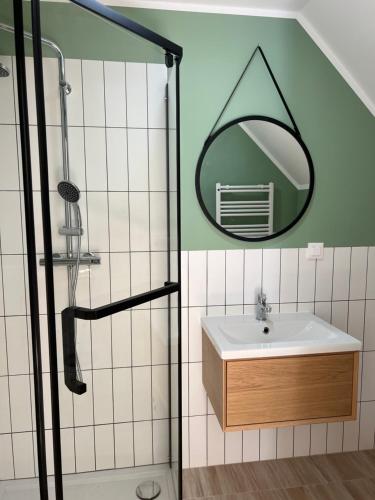 ein Bad mit einem Waschbecken und einem Spiegel in der Unterkunft Wilczy Zaułek in Mielno