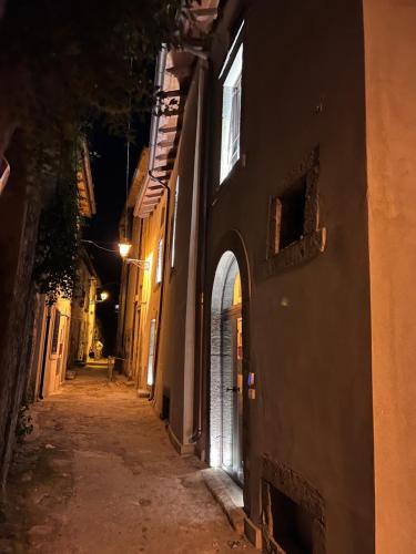 un callejón vacío por la noche con un edificio en Gelsi Luxury Suites, en Sora