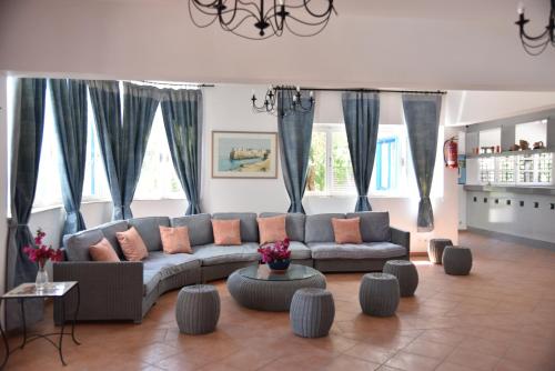 a living room with a couch and some windows at Boutique Hotel Tilos Mare in Livadia
