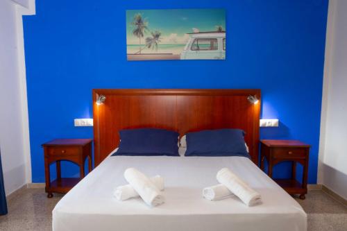 a blue bedroom with a bed with two pillows at APARTAMENTOS PALASIET in Benidorm
