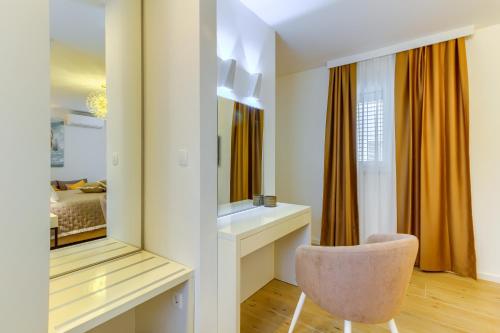 a dressing room with a chair and a mirror at Irini Luxury Rooms in Split