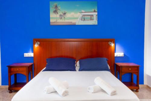 um quarto azul com uma cama com duas mesas de cabeceira em APARTAMENTOS PALASIET em Benidorm