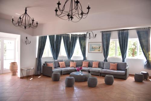 a living room with a couch and some windows at Boutique Hotel Tilos Mare in Livadia